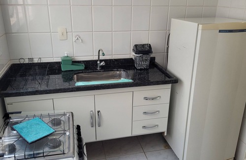 Mongagua Apartment | Apartamento moderninho, com sacada de frente para o mar. Sala bem iluminada.