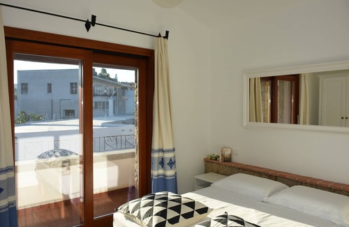 Lotzorai Apartment | Bedroom with double bed, veranda with view