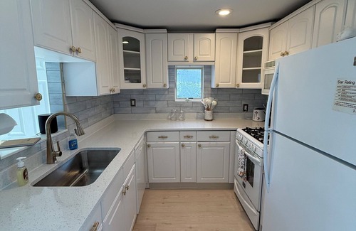 Warwick House | Freshly renovated waterfront retreat in Warwick Cove! This cozy 1-bedroom features a loft-style king bed, queen sleeper sofa, spacious deck, fenced yard, and open backyard leading to the water - perfect for a relaxing coastal escape.