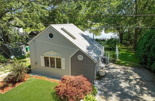 Warwick House | Freshly renovated waterfront retreat in Warwick Cove! This cozy 1-bedroom features a loft-style king bed, queen sleeper sofa, spacious deck, fenced yard, and open backyard leading to the water - perfect for a relaxing coastal escape.