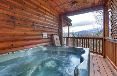 Gatlinburg - Pigeon Forge Cabin | Pet-friendly retreat with tree-top views, a hot tub + an arcade loft!