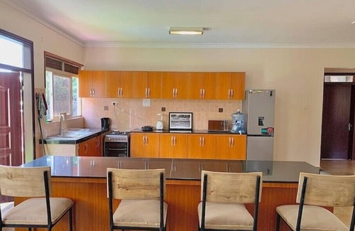 Kampala House | Quiet and peaceful hidden gem surrounded by lush greenery and vibrant flowers.n