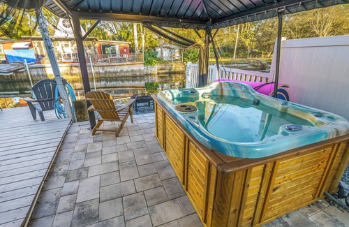 Weeki Wachee Gardens House | River home with huge arcade, hot tub kayaks, mini golf and floating pad, 80in TV