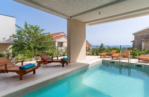 Mravince House | Vacation home with heated pool with covered terrace, stylish interior.
