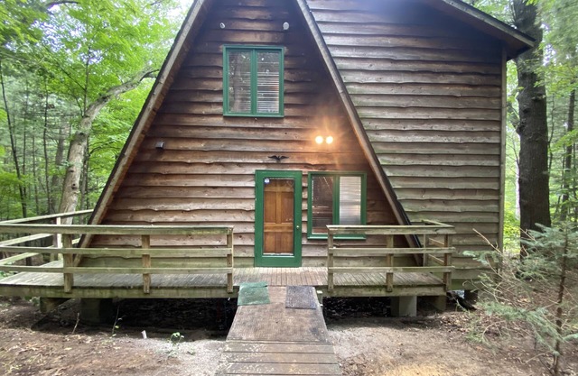 A-frame cabin nestled in forest, stunning lake view, perfect serenity.