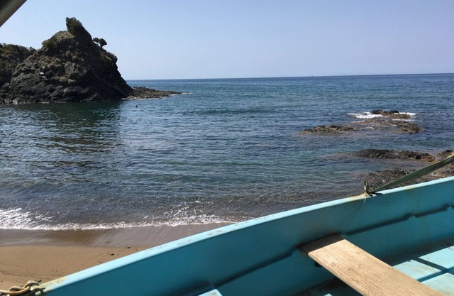 A house directly on the sandy beach with rocky coast, dreamlike object, view unique