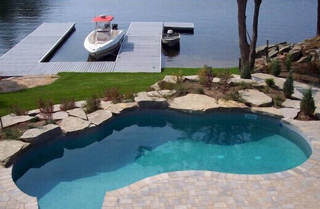 A luxurious villa nestled along the bay upon a rock , breathtaking sunset views