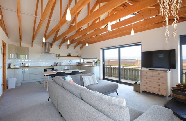 A modern, seafront chalet offering stunning beach views of Belhaven Bay.