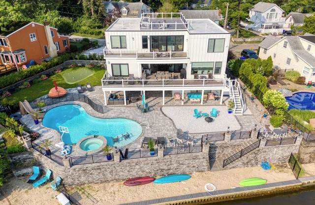 Beautiful waterfront 8-BR house w pool patio, outdoor bar, dock, putting green!
