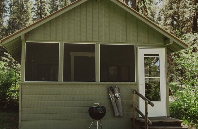 Huckleberry Cabin at Tamaracks Resort with a lake facing furnished screen porch.