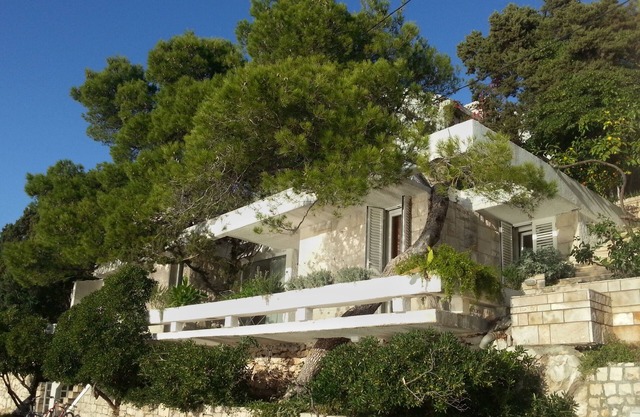Maison d'architecte avec grandes terrasses ombragées en front de mer.