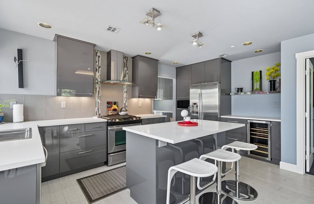 Top-level duplex featuring a sleek open concept kitchen with stainless appliances, cozy fireplace, stylish furnishings, and in-unit washer/dryer. Designed for basking in the sun under skylights in thoughtful details throughout.