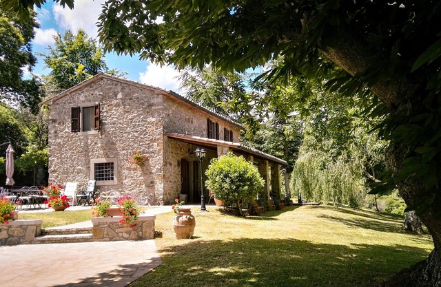 Tuscan stone villa with private pool surrounded by greenery