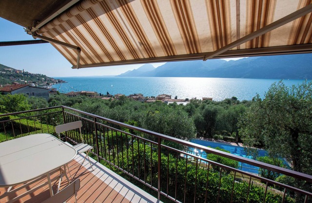 Wonderful balcony on the lake with beautiful pool and garden among palm and olive trees