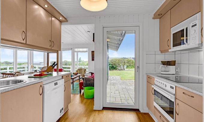 Helnæs By House | A simple cottage with terrace and bright living room.