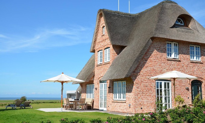 Großmorsum House | New building under thatch with an unobstructed view of the water.